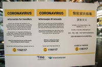 Plakaten med informasjon om koronaviruset henger blant annet på veggen i ankomsthallen på Oslo lufthavn.