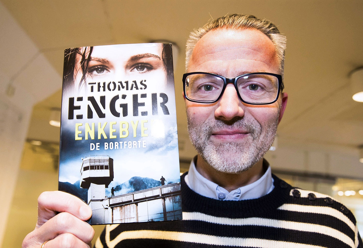 Forfatteren Thomas Enger med boka «Enkebyen – de bortførte». 